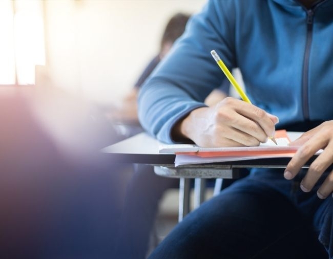 male sitting at a desk writing