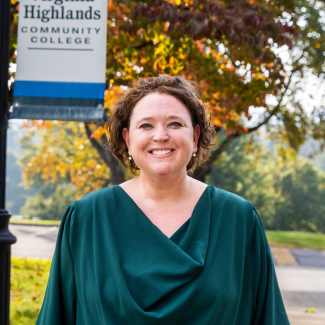 Headshot of Amanda Baldwin Estep smiling outdoors in front of a Virginia Highlands Community College sign.